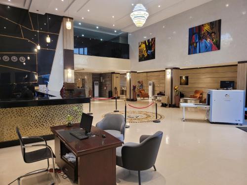 um átrio com uma secretária e cadeiras num edifício em Carlton Swiss Grand Hotel em Enugu