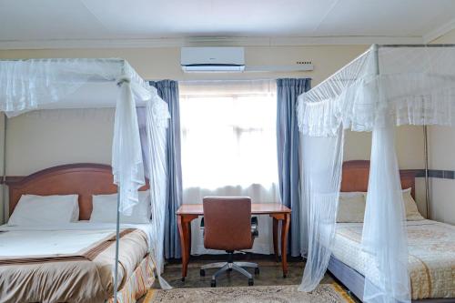 a bedroom with two bunk beds and a desk at Malabi Exclusive Lodges in Lilongwe