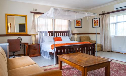 a bedroom with a bed with an canopy at Malabi Exclusive Lodges in Lilongwe