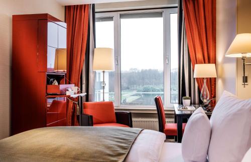 a hotel room with a bed and a desk and a window at Parkhotel Bremen – ein Mitglied der Hommage Luxury Hotels Collection in Bremen