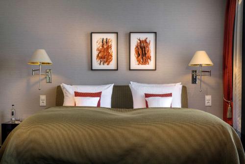 a bedroom with a large bed with three pictures on the wall at Parkhotel Bremen – ein Mitglied der Hommage Luxury Hotels Collection in Bremen