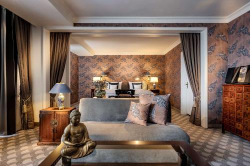 ein Schlafzimmer mit einem Bett und einer Statue in einem Zimmer in der Unterkunft Parkhotel Bremen – ein Mitglied der Hommage Luxury Hotels Collection in Bremen