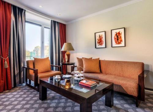 a living room with a couch and a table at Parkhotel Bremen – ein Mitglied der Hommage Luxury Hotels Collection in Bremen