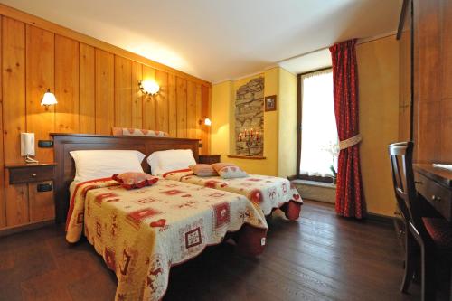 a bedroom with two beds and a window at L'Ancien Paquier Chambre D'Hotes in Valtournenche