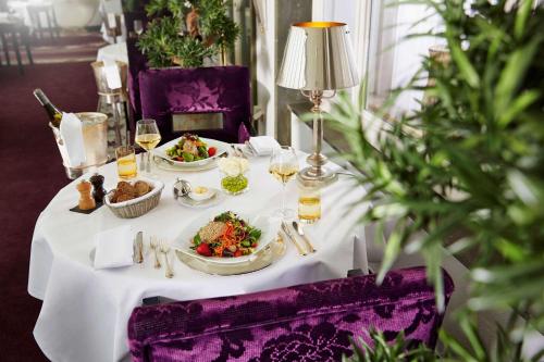 a white table with plates of food on it at Parkhotel Bremen – ein Mitglied der Hommage Luxury Hotels Collection in Bremen