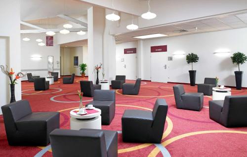 a large room with chairs and tables on a red carpet at B&K Hotels in Vlotho