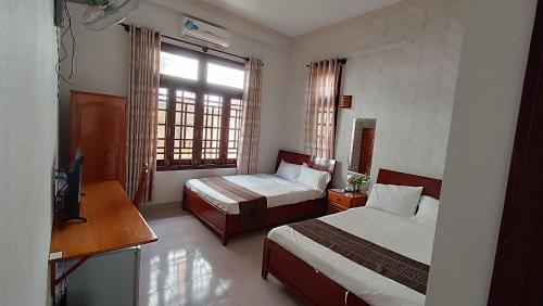 Chào Hotel Mũi Né في موي ني: غرفه فندقيه سريرين وتلفزيون