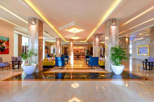 a lobby of a hotel with blue chairs and tables at Pickalbatros Aqua Park Sharm El Sheikh in Sharm El Sheikh