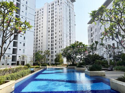 une piscine dans une ville avec de grands bâtiments dans l'établissement Bassura Apartment by Aok Property, à Jakarta