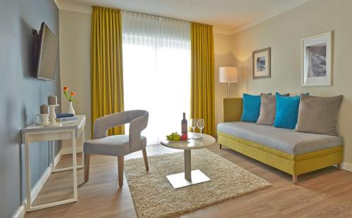 a living room with a couch and a table at Dorint Resort Baltic Hills Usedom in Korswandt