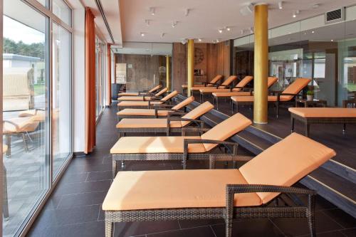 a row of tables and chairs in a restaurant at Dorint Resort Baltic Hills Usedom in Korswandt