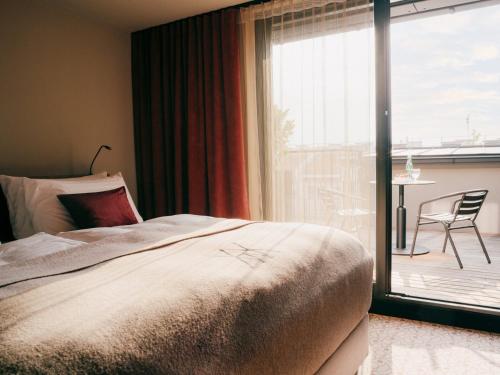a bedroom with a bed and a sliding glass door at WELTWIEN Luxury Art Apartments & Free Parking in Vienna