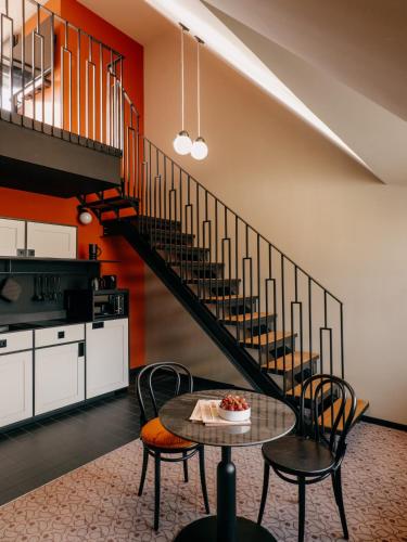 a living room with a staircase and a table and chairs at WELTWIEN Luxury Art Apartments & Free Parking in Vienna