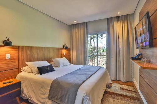 a bedroom with a large bed and a window at Ti Voglio Bene in Campos do Jordão
