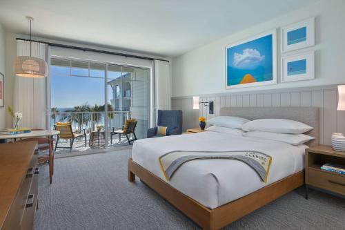 The Seabird Ocean Resort & Spa, Part of Destination Hotel by Hyatt في أوشن سايد: غرفة نوم بسرير كبير وغرفة معيشة
