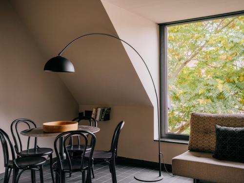 ウィーンにあるWELTWIEN Luxury Art Apartments & Free Parkingのテーブルと椅子と窓のある部屋