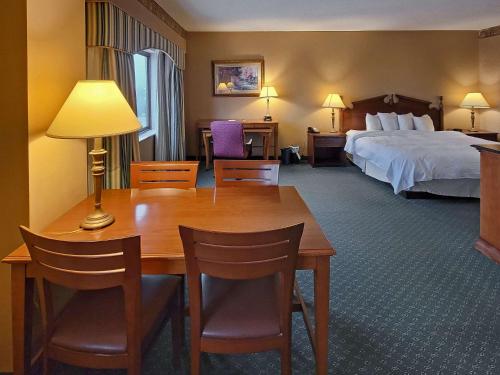a hotel room with a bed and a table and chairs at Radisson Hotel Cedar Rapids in Cedar Rapids