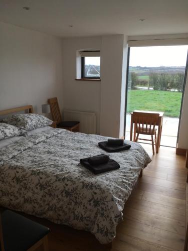 a bedroom with a bed with two black towels on it at Red Brick Barn in Sutton under Brailes