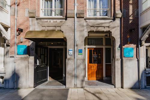 a building with two entrances to a building with brown doors at Hotel JL No76 in Amsterdam