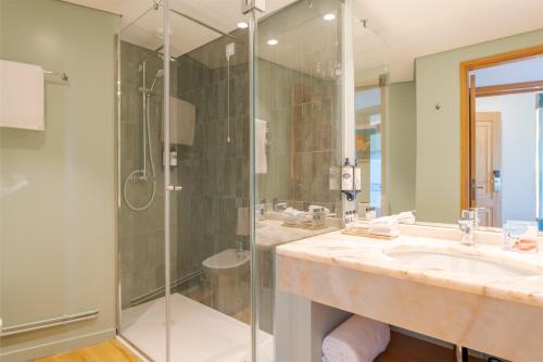 bagno con doccia in vetro e lavandino di Pestana Vila Lido Madeira Ocean Hotel a Funchal