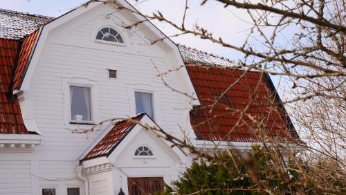 een wit huis met een rood dak bij Pensionat Solhöjden in Mariannelund
