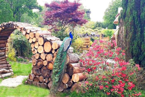 a garden with a stone bridge and a pile of logs at Little Thatch in Corfe Castle