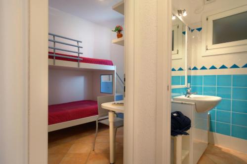 een badkamer met een wastafel en een stapelbed bij Perla Del Porto Apartments in Santa Teresa Gallura