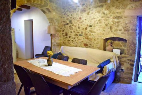 a dining room with a table and a stone wall at Villa Drogari in Éxo Apídhion