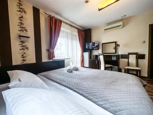 a bedroom with a large bed with two towels on it at Hotel Mieszko in Rzeszów