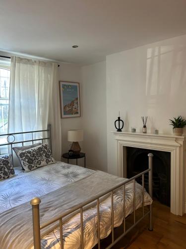 1 dormitorio con 1 cama y chimenea en 2bed house in Vauxhall, en Londres