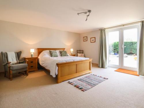 a bedroom with a bed and a chair and a window at Bramble Lodge in Northwich