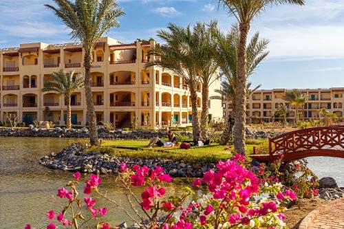 a resort with palm trees and flowers in front of it at Robinson Soma Bay in Hurghada