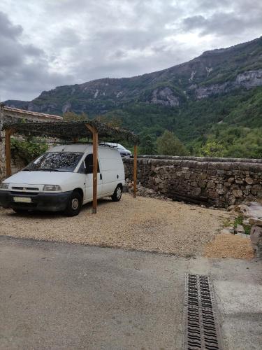 a white van parked next to a stone wall at Chambre atypique : La Grotte in Bez-et-Esparon