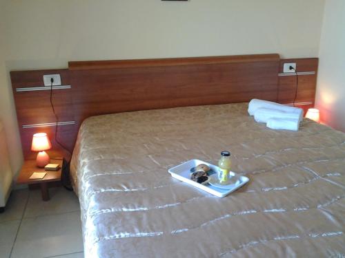a tray with a drink and a bottle on a bed at B&B Alicino in Cerfignano