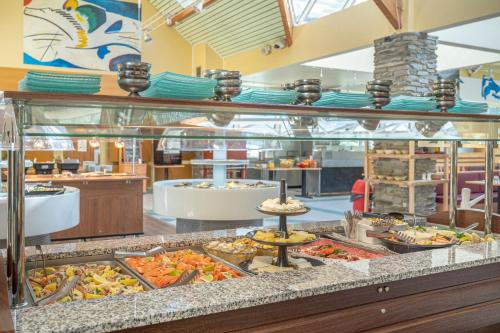 a buffet line with many different types of food at Village Club Les Balcons des Pyrénées in Saint-Mamet
