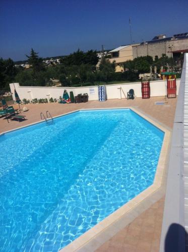 a large swimming pool with blue water at B&B Alicino in Cerfignano