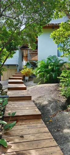 a wooden pathway leading to a house with trees at Villa on the Rock - Luxury, Privacy, Pool, Sea View in Koh Phangan in Thong Sala