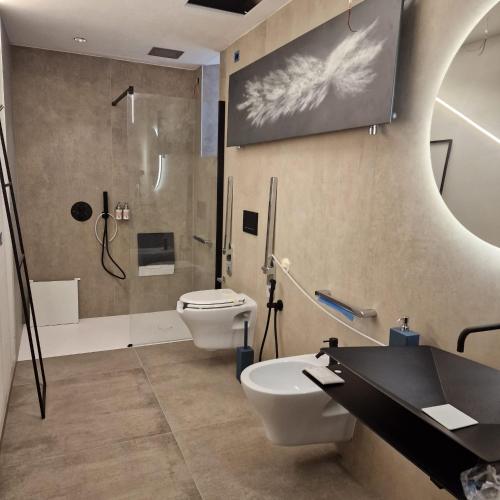a bathroom with a shower and a toilet and a sink at Langhe Country House in Neive