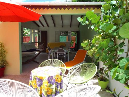 a patio with chairs and a table and an umbrella at Sunbeachparadise in Port-Louis