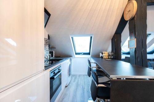 une cuisine avec un comptoir noir dans une pièce dans l'établissement Le cocon Thérèse, à Metz