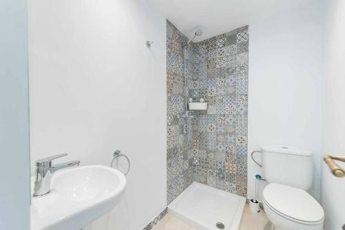 a white bathroom with a toilet and a sink at Green Maca, adosado centro Campanet in Campanet