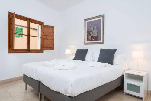 a large white bed in a room with a window at Green Maca, adosado centro Campanet in Campanet