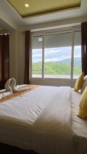 a large white bed in a room with a large window at Hill Monk - Bethany Heights in Vagamon