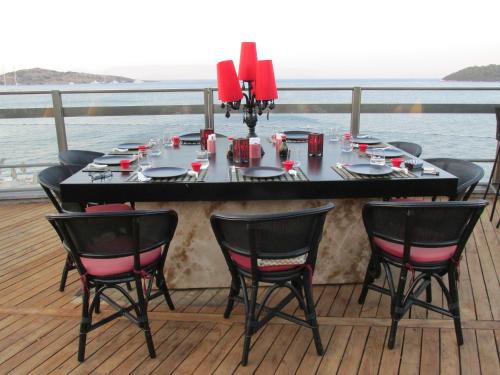 a dining table on a deck with a view of the ocean at Kuum Hotel & Spa in Golturkbuku