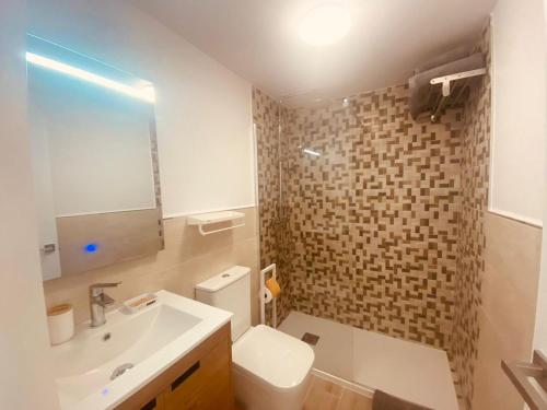 a bathroom with a white toilet and a sink at La Perla in Playa de las Americas