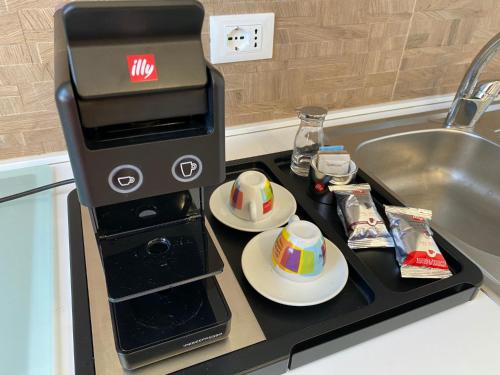 a coffee maker on a counter next to a sink at Marina di Petrolo Apartments in Castellammare del Golfo