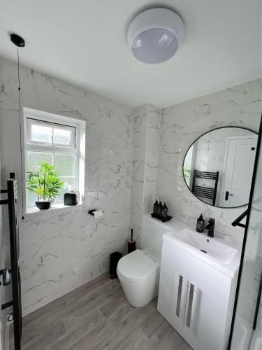 Baño blanco con aseo y lavamanos en Stunning apartment in Beckton with Private Entrance en Londres