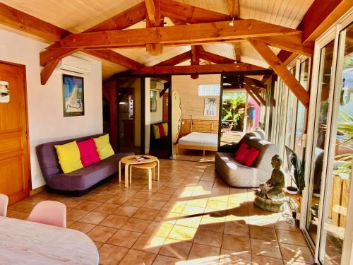 a living room with couches and a table at Villa Patio + jacuzzi, FREE Surf+Body+Sup in Capbreton