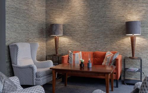 a living room with a couch and two chairs and a table at Home Hotel Wellington in Stockholm