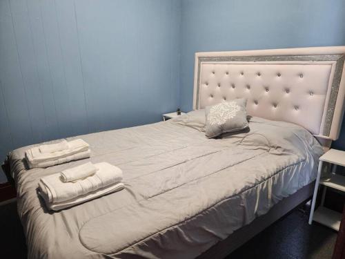 1 dormitorio con 1 cama grande y toallas. en Urban Getaway on 7th, en Niagara Falls